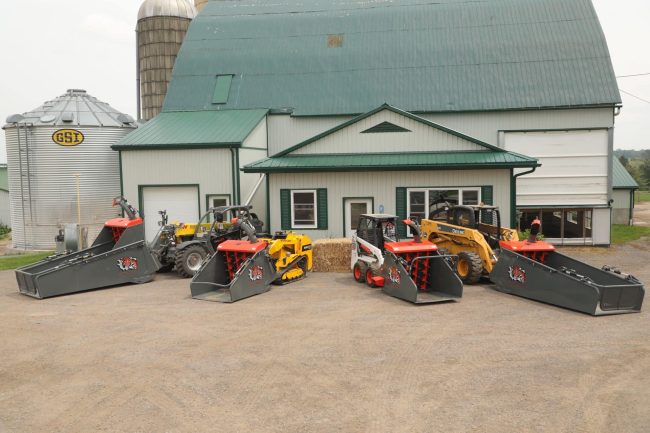 strawmaster2 a variety of skids steers, each with a different straw blower attached to them, sit in front of a barn