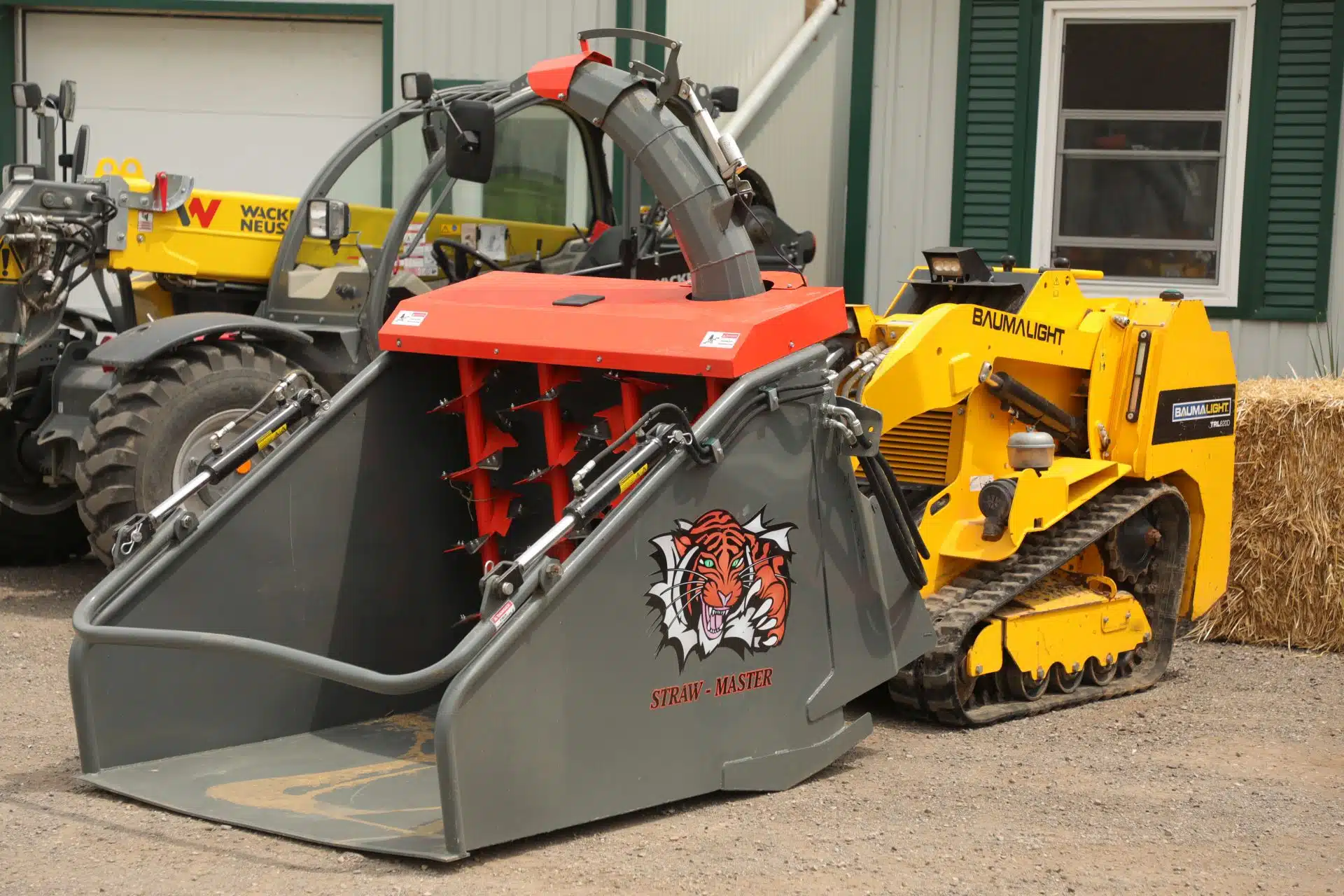 a mini skid steer has a smaller straw processor attached to it